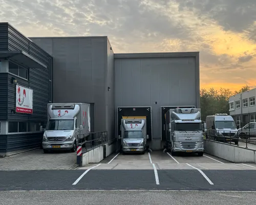 Eén bakbus en twee vrachtwagens staan klaar voor het laadperron van J. van de Kraats Kipspecialiteiten