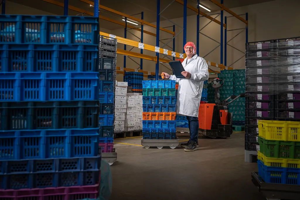 John van de Kraats controleert een partij kipproducten in de expeditiehal met thermometer en schrijfblok